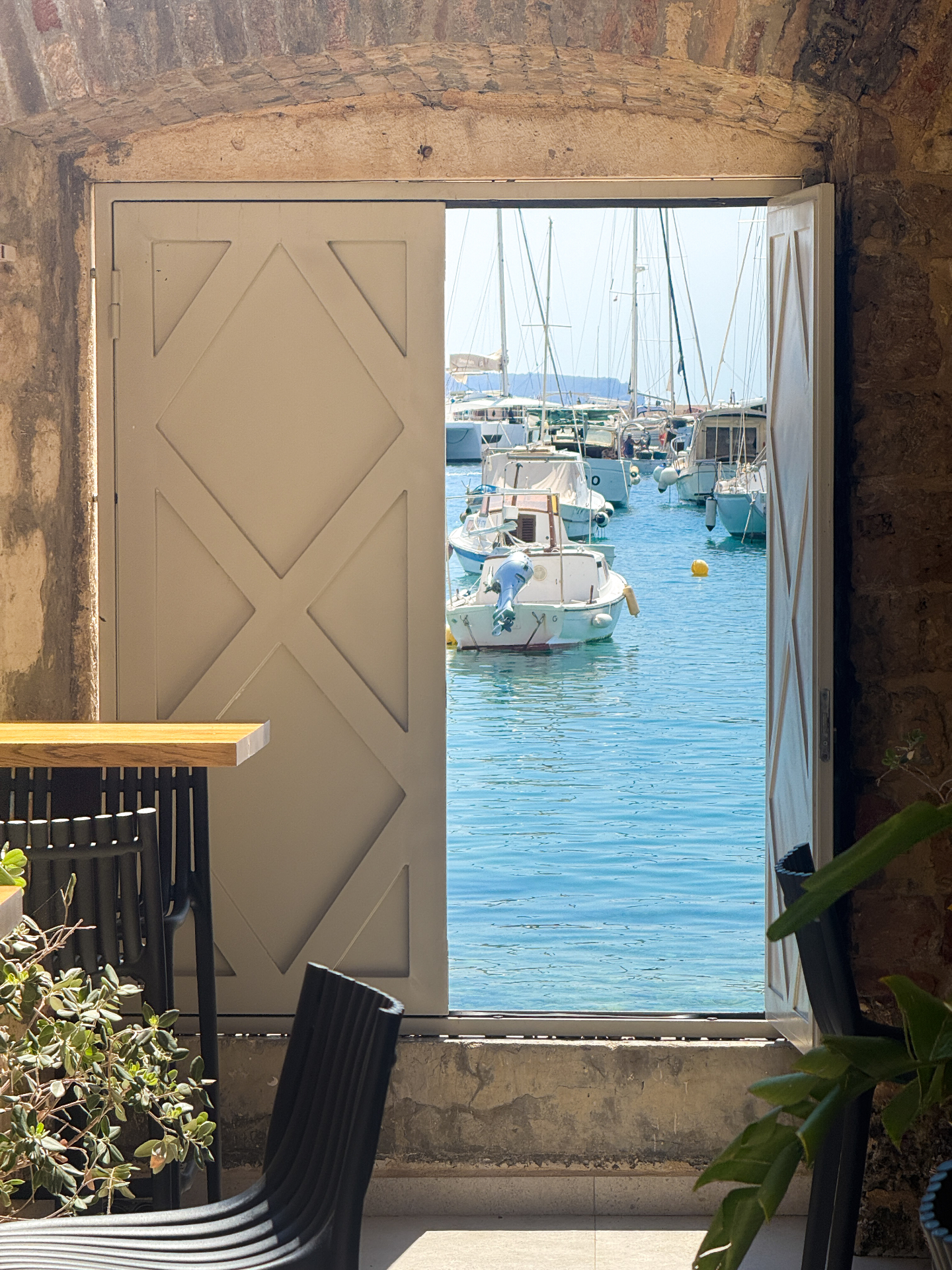 Harbor door opening to boats on turquoise water