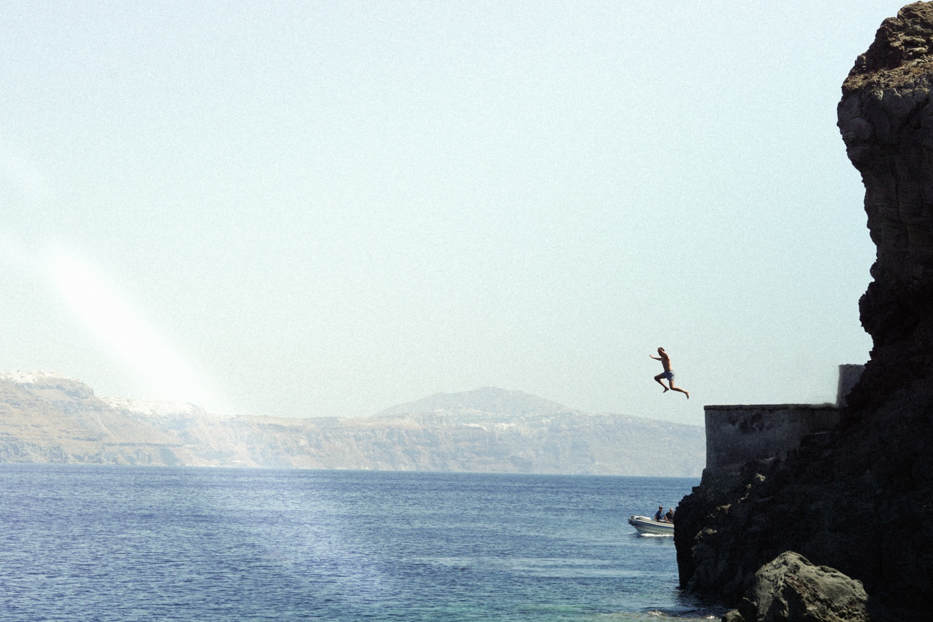 Cliff jumper over the Aegean in Santorini
