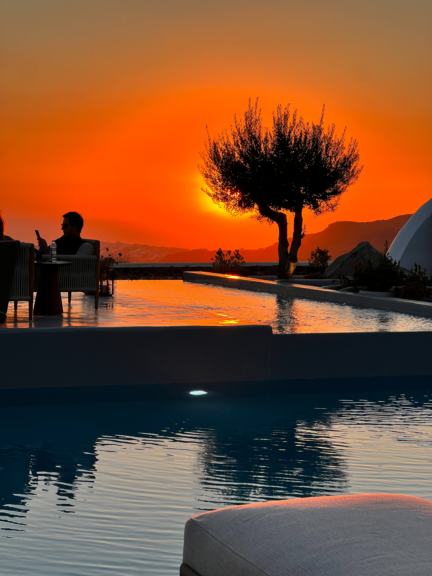 Sunset over a pool in Santorini